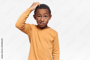Isolated image of perplexed frustrated African American schoolboy grimacing and looking up, scratching his head, having confused facial expression, forgot something important. Body language
