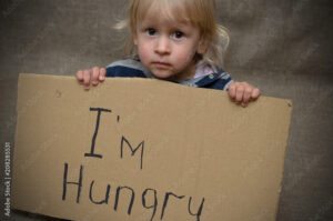 A hungry boy and a girl with a cardboard tablet with the inscription I'm hungry . The social problem.