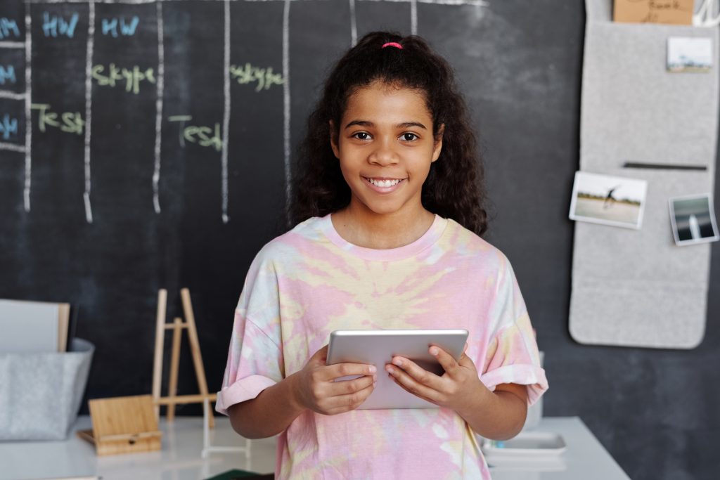 Woman in pink crew neck t shirt holding tablet computer