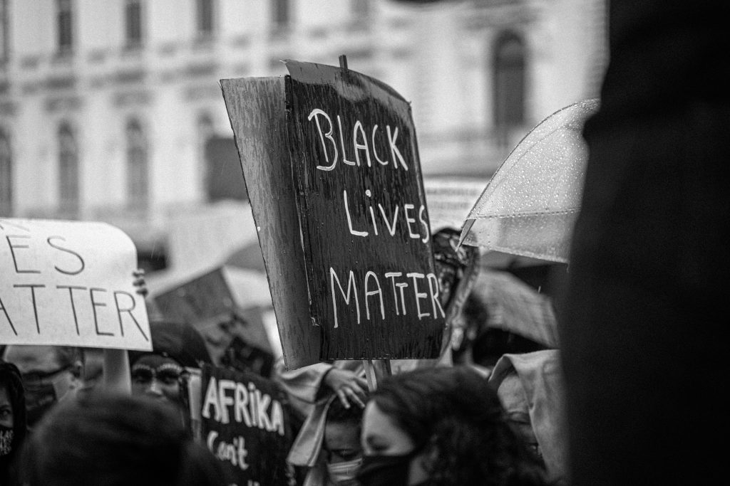 Unrecognizable activists with black lives matter title on placard