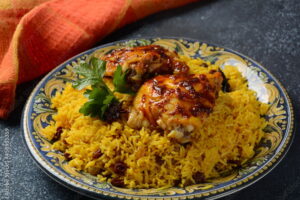 The national Saudi Arabian dish chicken kabsa with roasted chicken quarter and almonds, raisins, garlic and biryani rice