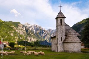 Flock of sheep and Catholic Church in Theth, Theth National Park, Albanian Alps, Prokletije, Qark Shkodra, Albania, Europe