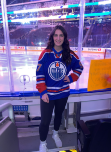 Picture of Avery Standing in front of the glass at the Rogers arena in Edmonton. 