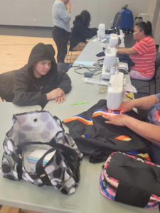 Community members helping the students sew