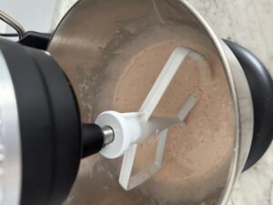 cherry chip cake batter in a black kitchen aid electric hand mixer