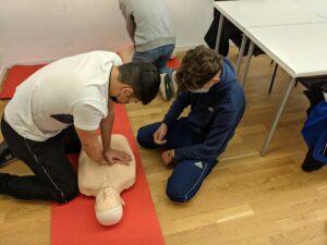 People practice CPR on a mannequin.