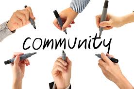 6 hands writing the word community together