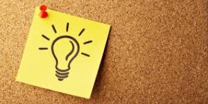 bulletin board with a pinned sticky note that has a light bulb on it