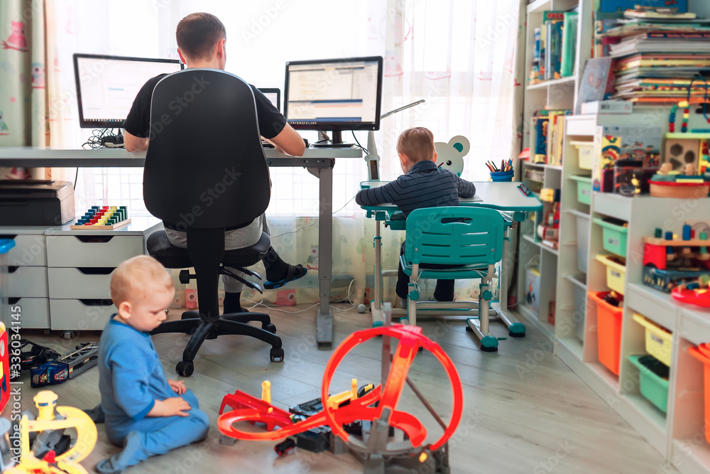 Father with kids working from home during quarantine. Stay at home, work from home concept during coronavirus pandemic