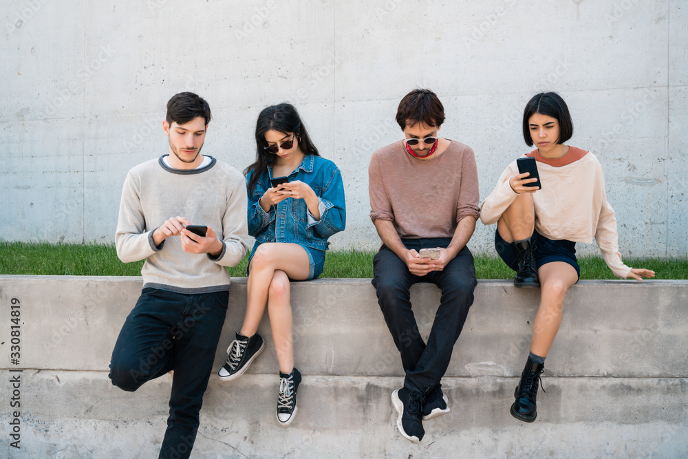 Group of friends using their phones.