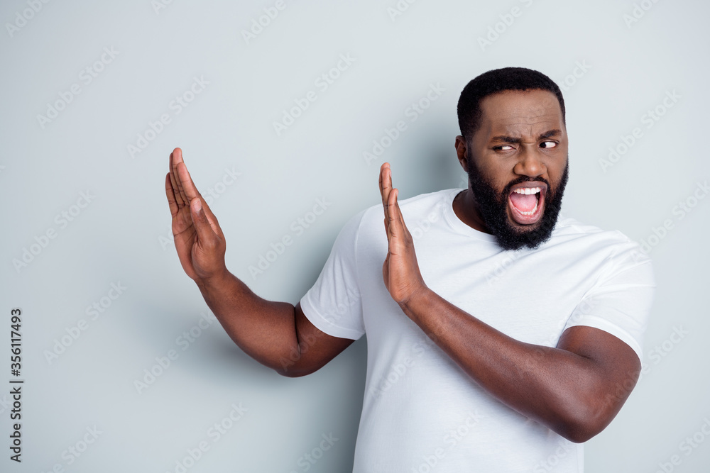 Photo of yelling displeased dark skin african guy antiracism group leader say no violence behavior to black people lawlessness raise arms palms empty space isolated grey color background