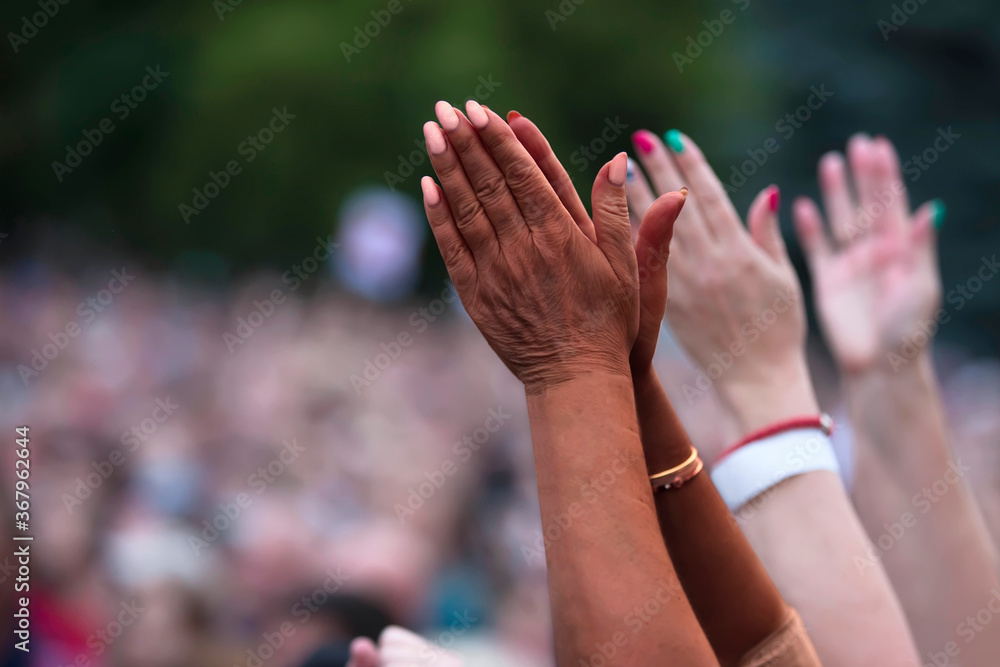 The black man raised his hands in protest. Social justice and peaceful protesting racial injustice. Black and white hands together against the background of a blurred crowd of people.