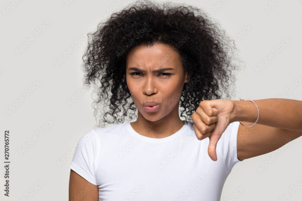 Unsatisfied african woman showing thumb down disapproval gesture