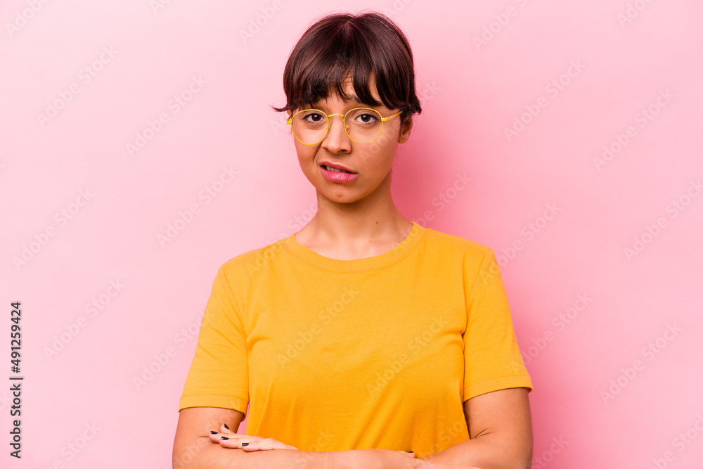 Young hispanic woman isolated on pink background unhappy looking in camera with sarcastic expression.