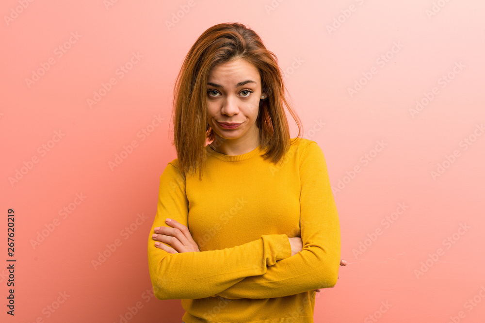 Young pretty young woman unhappy looking in camera with sarcastic expression.