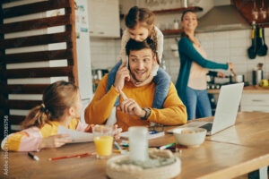 Small daughters distracting their working father who is making phone call at home.