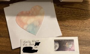 A homemade valentine featuring a watercolour heart and a stamped envelope 