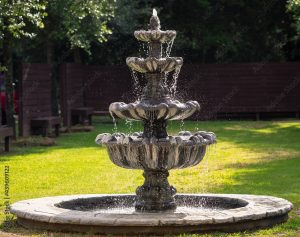 stone water fountain in a garden with water splashing