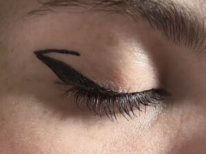 Larger black wing. Small black line going into the crease of the eye from the top of the wing. 