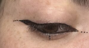 Small winged liner hugging the lash line. The dots near end of the wing and on inner corner. there are three dots under the eye.