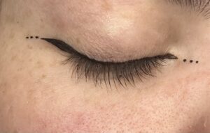 Small winged liner hugging the lash line. The dots near end of the wing and on inner corner. 