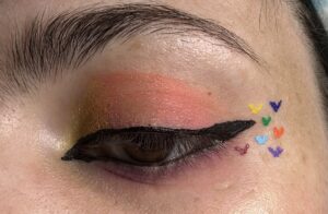 Close up of slightly open eye. yellow on inner corner and slow transitions into a redish pink.