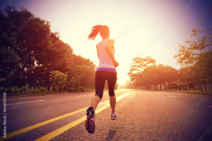 Runner athlete running on sunrise road