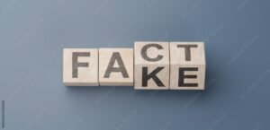 cubes turning message FACT to FAKE. Turned wooden cubes with words Fact vs Fake. Blue background. Business and Fact vs Fake concept