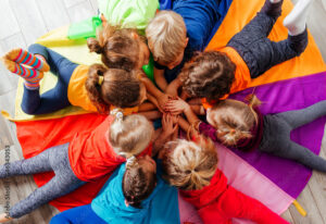 Cheerful children playing team building games on a floor