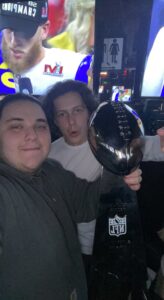 a photo of me with a friend holding a mock Lombardi trophy