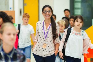 Junior high students walking around smiling female teacher