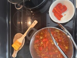 Cooking vegetables in beef stock. Took peppers out of pot and place into separate bowl.