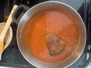 Roast beef simmering in sauce.