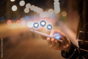 Woman hands using mobile smartphone in the street with icon social media and social network.