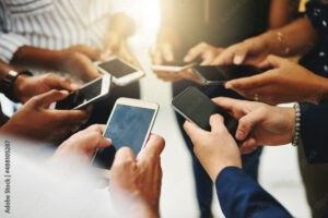 Theres no faster way to spread the word than online. Closeup shot of a group of unrecognizable businesspeople using their cellphones in synchronicity.