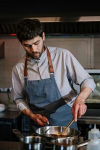 Man in white chef uniform holding chopsticks