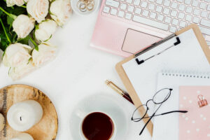 Stylish flatlay frame arrangement with pink laptop, tea, roses, glasses and other accessories on white. Feminine business mockup, copyspace