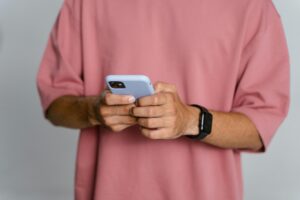 Person in pink long sleeve shirt holding silver iphone 6