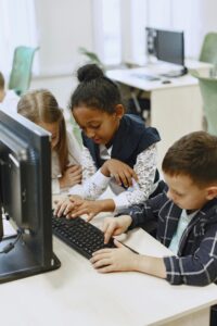 Image of kids in front of computer typing on a keyboard