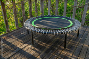 mini trampoline for fitness exercising and rebounding in a backyard patio, spring scenery
