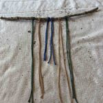 macramé cord knotted onto a stick with lark heads knot.