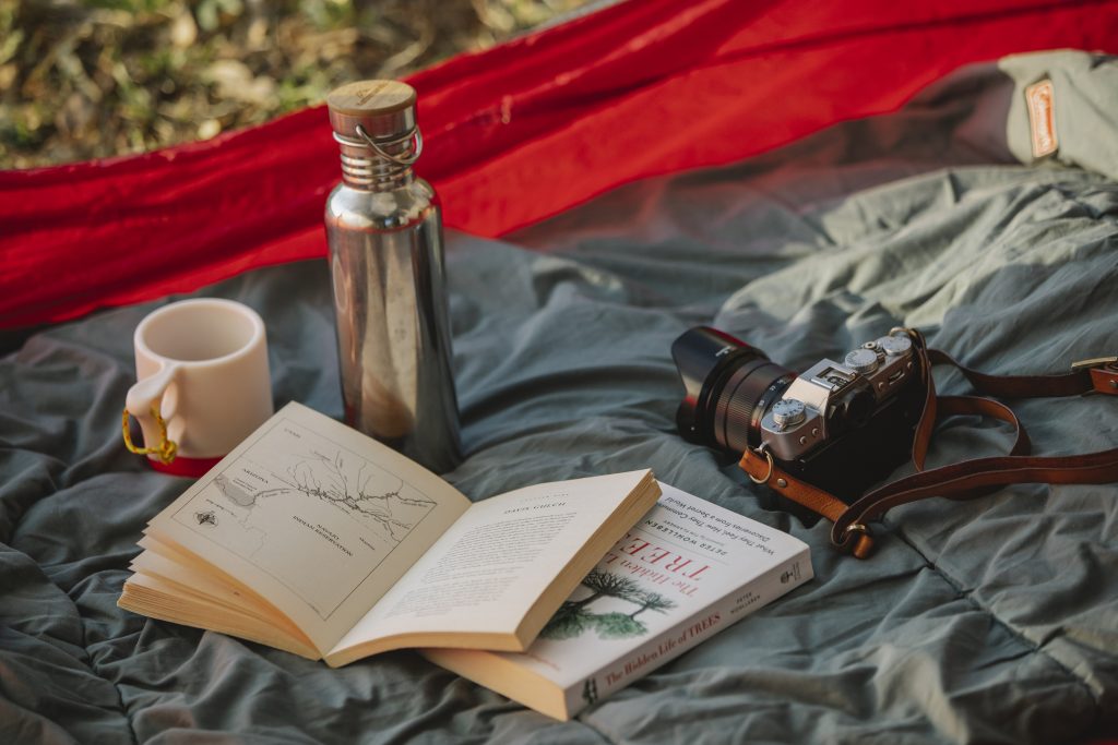 Thermos books and photo camera on camp tent