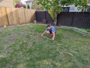 Me measuring the radius of the firepit and paving stones.