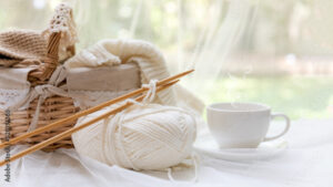 Coffee morning.  White steaming cup of hot coffee for relax after working hobbies crochet on white wooden near window