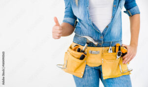Close-up woman construction worker wearing tool belt showing thumbs up on white