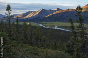 The last rays of sunlight hit the tops of the mountains along the Wind River in the Peel watershed; Yukon, Canada