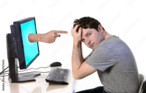 man with computer finger pointing cybermobbing and bullying