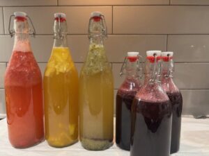 Different flavors of Kombucha in glass bottles on a counter. 