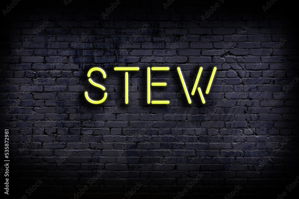 Neon sign. Word stew against brick wall. Night view