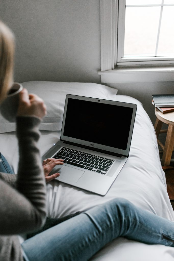 Woman in gray sweater using macbook air